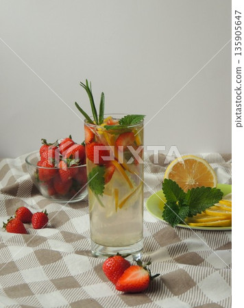 drink with lemon, strawberry and mint on a tablecloth on a gray background drink with lemon, strawberry and mint on a tablecloth on a gray background 135905647