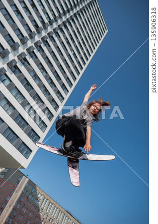 Girl practices skiing tricks on a trampoline.  135906318