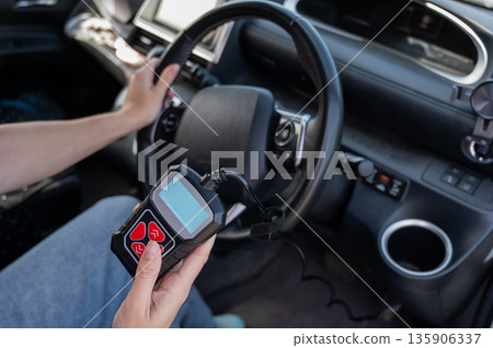 Woman using OBD2 diagnostic scanner. Woman using OBD2 diagnostic scanner. 135906337