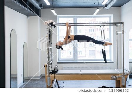 Caucasian woman doing pilates on reformer.  135906362