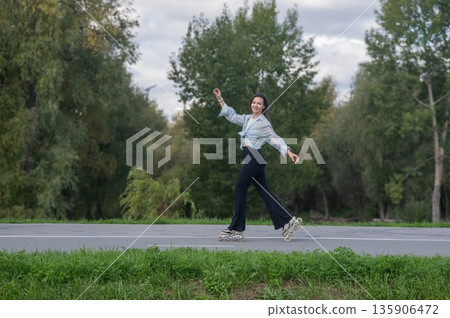 Caucasian woman roller skating in park. Caucasian woman roller skating in park. 135906472