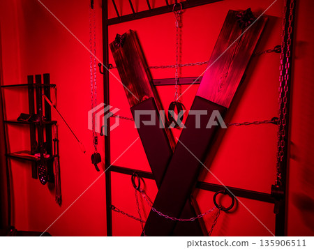 BDSM set. Leather accessories on a wooden cross. BDSM set. Leather accessories on a wooden cross. 135906511