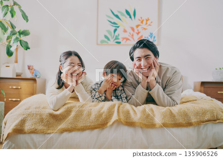 Family lying on bed Family lying on bed 135906526