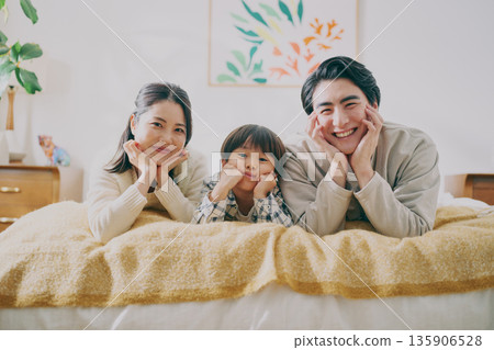 Family lying on bed 135906528