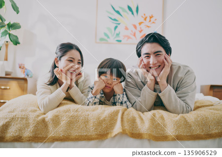 Family lying on bed 135906529