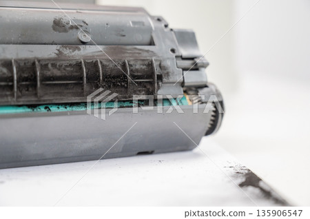 Broken laser printer cartridge on white background.  135906547