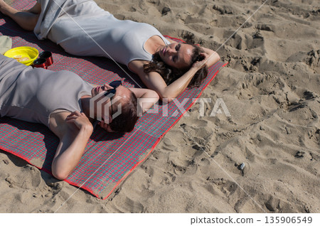 Two Caucasian women relaxing on the beach.  135906549