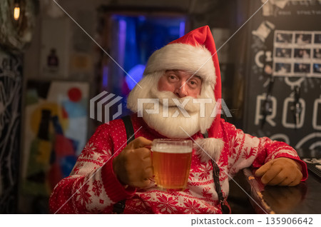 Santa Claus drinking beer at a bar.  135906642
