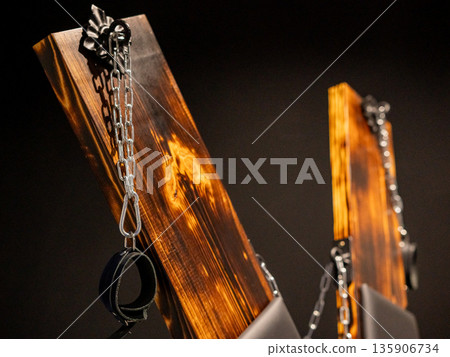BDSM set. Leather accessories on a wooden cross. BDSM set. Leather accessories on a wooden cross. 135906734