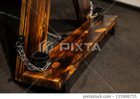 BDSM set. Leather accessories on a wooden cross. BDSM set. Leather accessories on a wooden cross. 135906735
