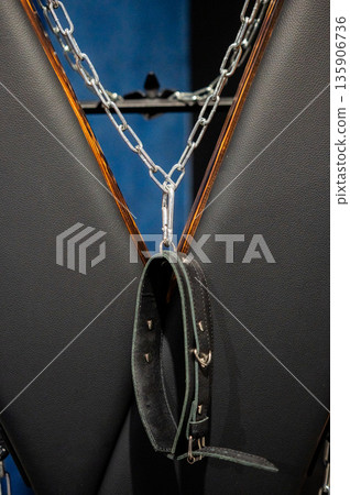 BDSM set. Leather accessories on a wooden cross. BDSM set. Leather accessories on a wooden cross. 135906736
