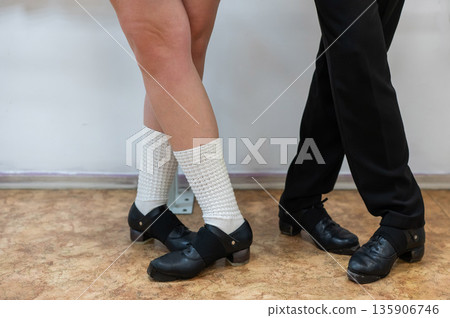 Close-up of female and male legs dancing traditional Irish stepdance. Close-up of female and male legs dancing traditional Irish stepdance. 135906746