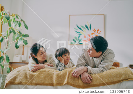 Family lying on bed Family lying on bed 135906748