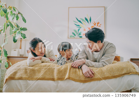 Family lying on bed 135906749