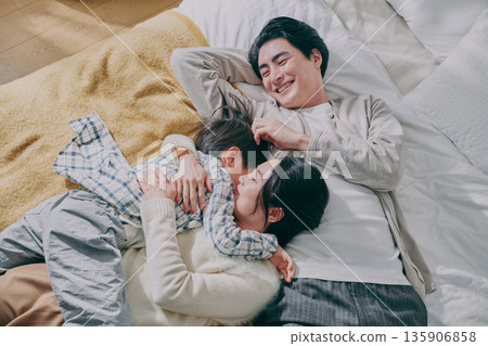 Family lying on bed Family lying on bed 135906858