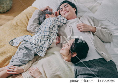 Family lying on bed Family lying on bed 135906860