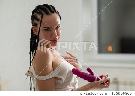 Caucasian woman holding a pink dildo.  135906866