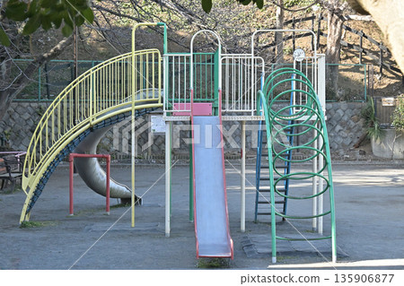 A park with a retro Showa-era atmosphere featuring slides and jungle gyms 135906877