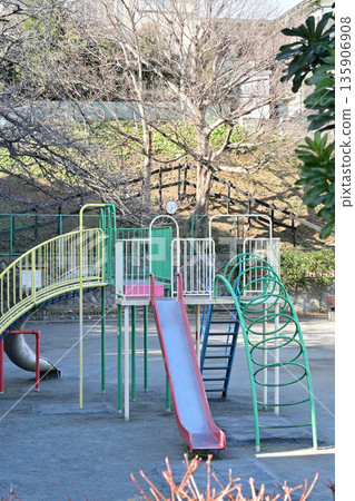 A park with a retro Showa-era atmosphere featuring slides and jungle gyms 135906908