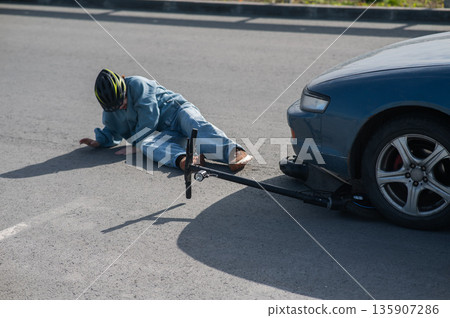 A Caucasian woman on a scooter after being hit by a car. 135907286