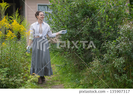 Young Caucasian woman trimming bushes. Young Caucasian woman trimming bushes. 135907317
