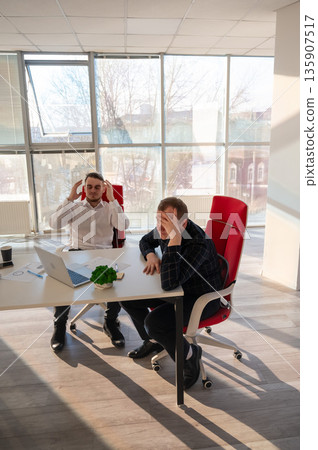Two Caucasian men solve problems at work. Two Caucasian men solve problems at work. 135907517