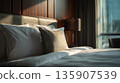 Cozy bedroom with soft lighting and neatly arranged pillows in a modern hotel room during the evening 135907539