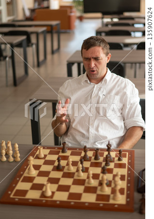 Middle aged Caucasian man playing chess. Middle aged Caucasian man playing chess. 135907624