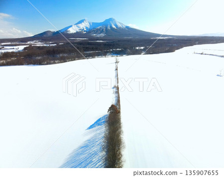 Aerial view of snowy fields and Mt. Komagatake in Mori Town, Hokkaido in winter Aerial view of snowy fields and Mt. Komagatake in Mori Town, Hokkaido in winter 135907655