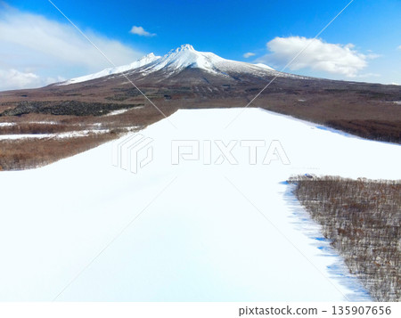 Aerial view of snowy fields and Mt. Komagatake in Mori Town, Hokkaido in winter Aerial view of snowy fields and Mt. Komagatake in Mori Town, Hokkaido in winter 135907656