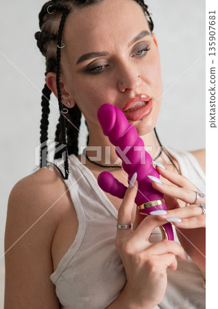 Caucasian woman holding a pink dildo. Caucasian woman holding a pink dildo. 135907681