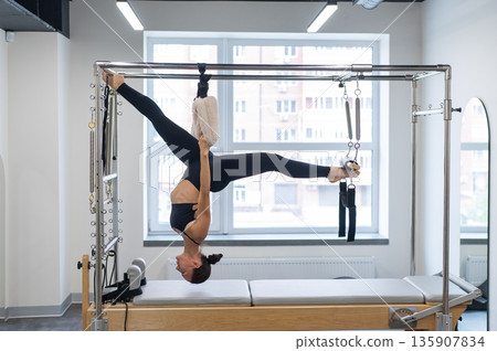 Caucasian woman doing pilates on reformer.  135907834