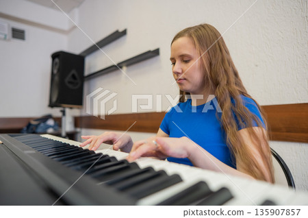 Caucasian woman playing electric piano.  135907857