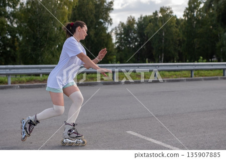 Caucasian woman in shorts roller skating.  135907885
