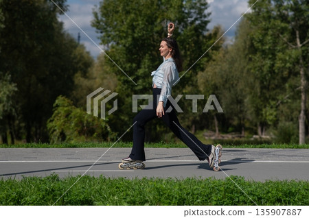Caucasian woman roller skating in park.  135907887
