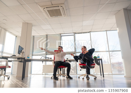 Two Caucasian men having fun at work. Two Caucasian men having fun at work. 135907908