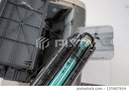 Broken laser printer cartridge on white background. Broken laser printer cartridge on white background. 135907934