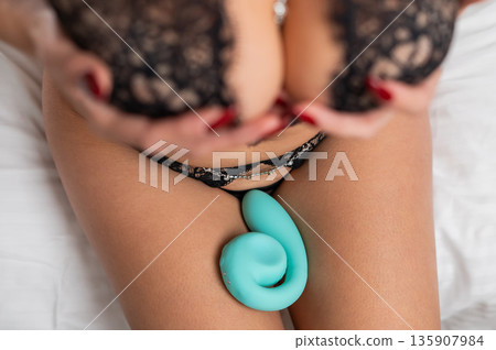 A woman in underwear holds a vibrator.  135907984