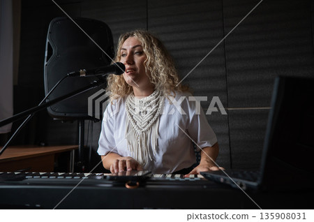 Caucasian woman singing into microphone and playing synthesizer.  135908031