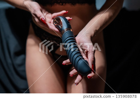 Woman in lace lingerie holds a dildo. Woman in lace lingerie holds a dildo. 135908078