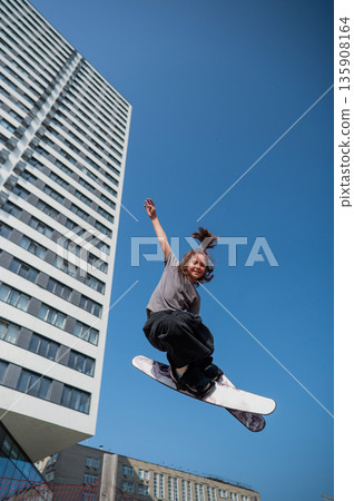 Girl practices skiing tricks on a trampoline. Girl practices skiing tricks on a trampoline. 135908164