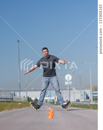 A Caucasian man rollerblades around the slalom course. A Caucasian man rollerblades around the slalom course. 135908165