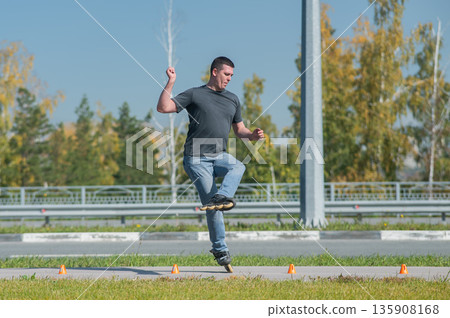 A Caucasian man rollerblades around the slalom course. 135908168