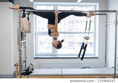 Caucasian woman doing pilates on reformer.  135908247