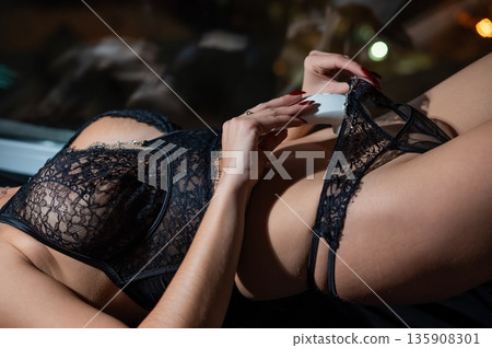 Woman using white clitoral vacuum stimulator.  135908301