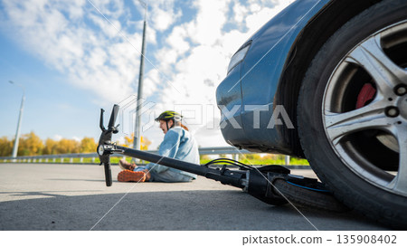 A Caucasian woman on a scooter after being hit by a car. 135908402