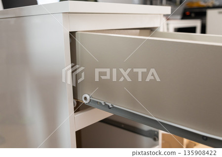 A pristine white open drawer revealing its precise roller mechanism, highlighting modern furniture construction, efficient storage solutions, and home interior design A pristine white open drawer revealing its precise roller mechanism, highlighting modern furniture construction, efficient storage solutions, and home interior design 135908422