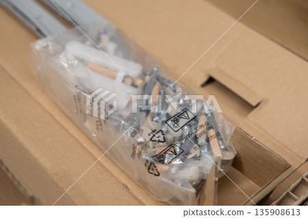 Clear plastic bag containing diverse furniture hardware components for convenient do-it-yourself assembly, reflecting home improvement and installation Clear plastic bag containing diverse furniture hardware components for convenient do-it-yourself assembly, reflecting home improvement and installation 135908613