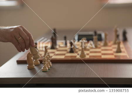 Close up of hands of middle aged caucasian man playing chess. Close up of hands of middle aged caucasian man playing chess. 135908755
