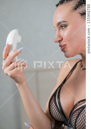 Caucasian woman holding a vacuum vibrator. Caucasian woman holding a vacuum vibrator. 135908788